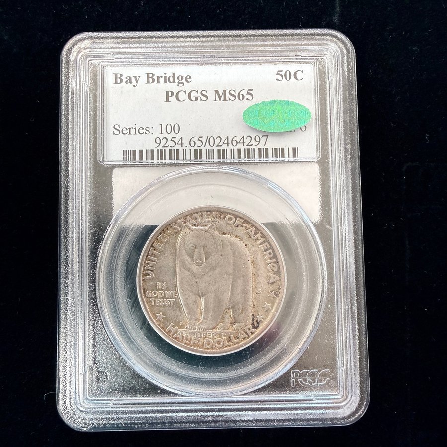 A Bay Bridge commemorative half dollar with a bear design, graded MS65 by PCGS